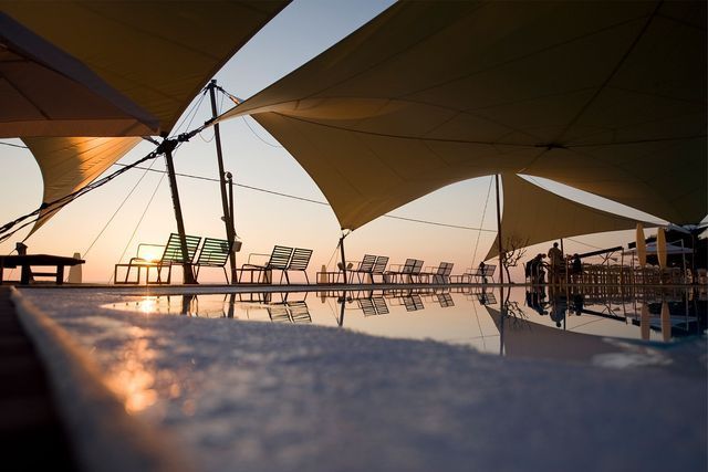 Una piscina con sombrillas y sillas a su alrededor