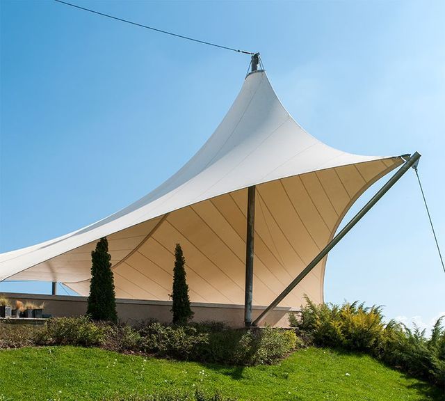 Una gran tienda blanca está situada en la cima de una colina cubierta de hierba