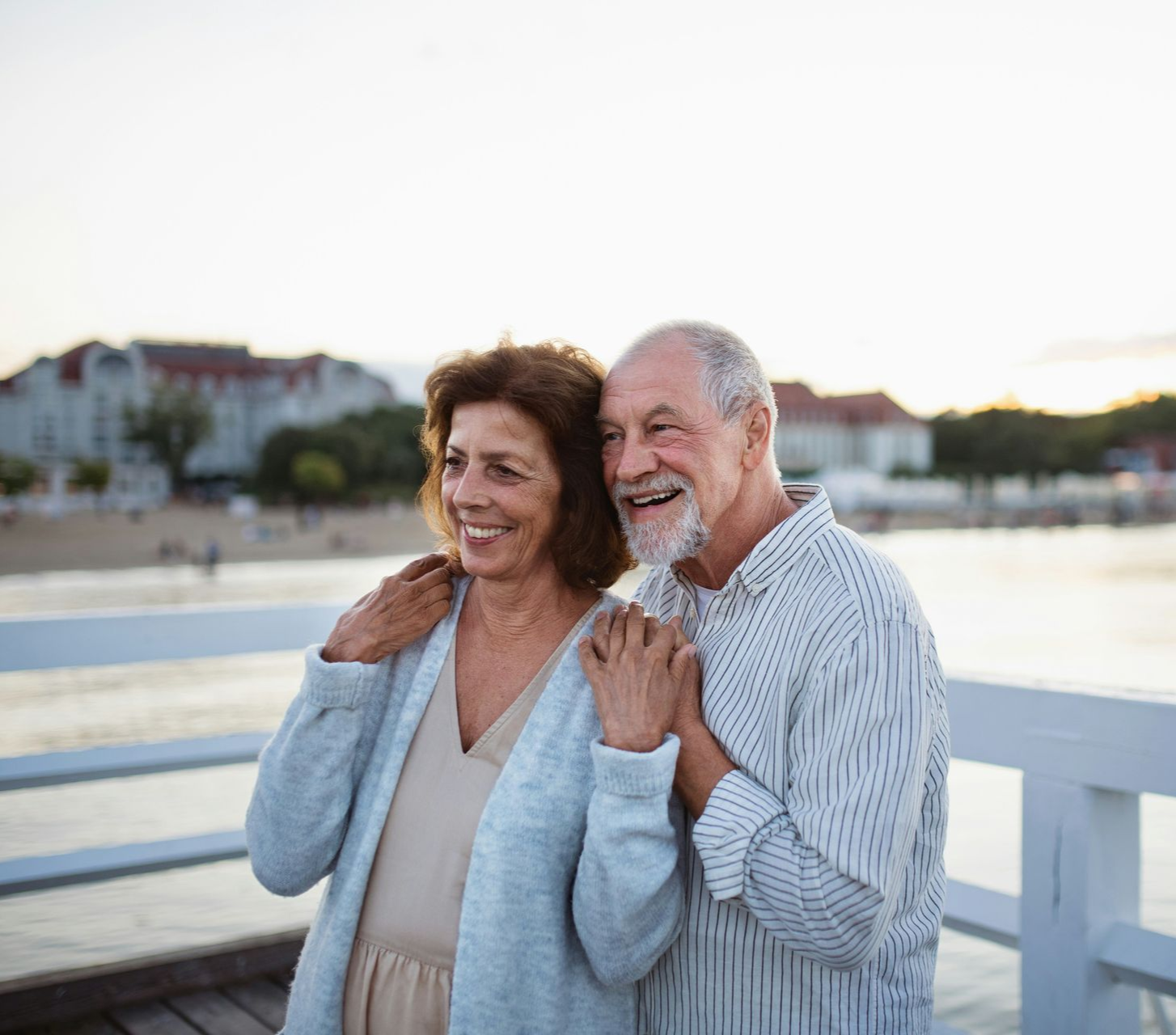Modern glass building reflecting a bright blue sky with wispy clouds.