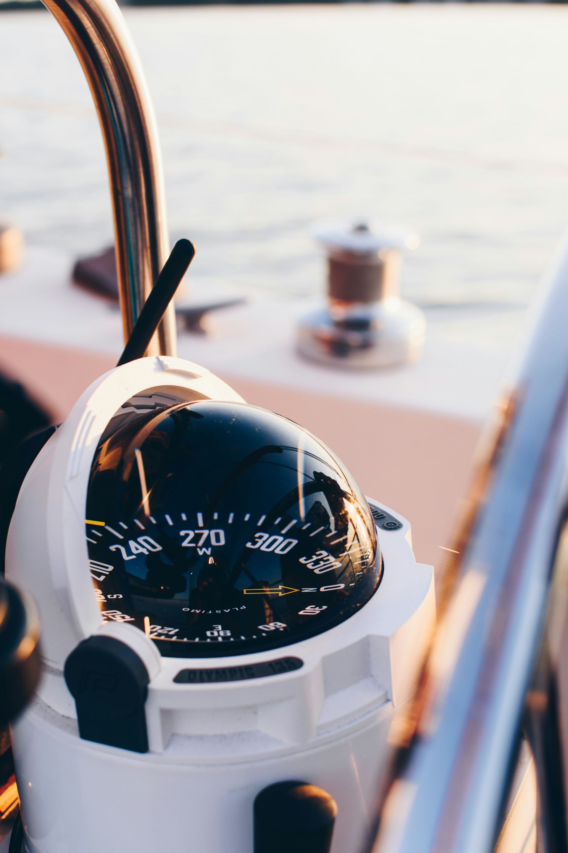 Compass on a sailboat, reading 270 degrees; close-up shot with blurred background.