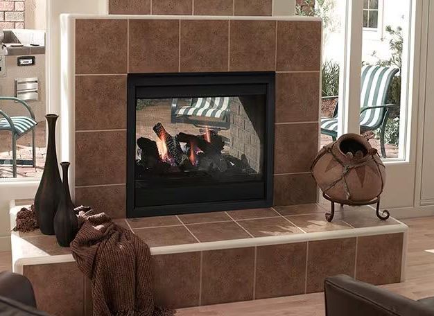A brown tiled fireplace with a burning fire, decorative vases, and a draped fabric in a living room setting.