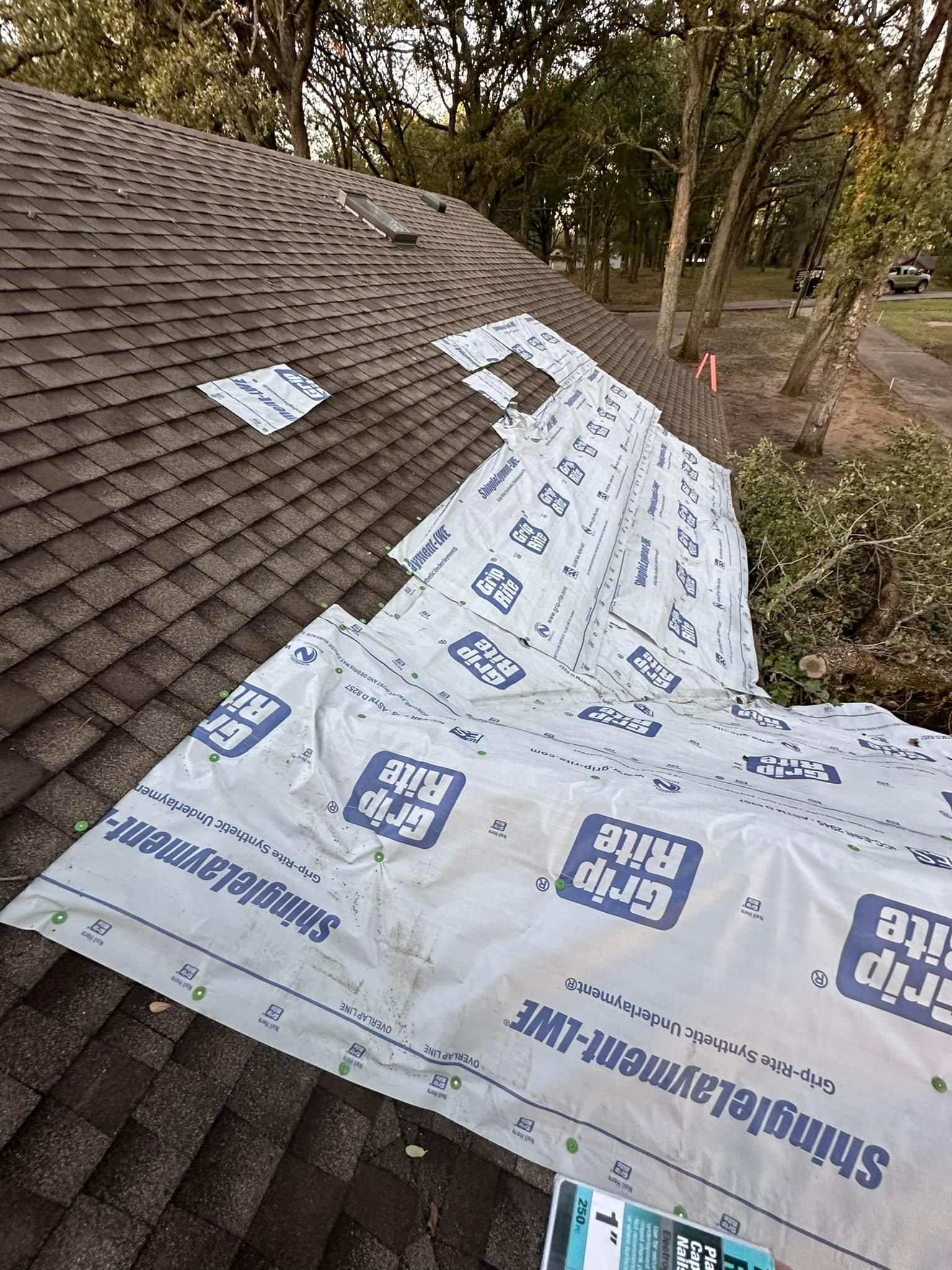 Shingles are being installed on the roof of a house.
