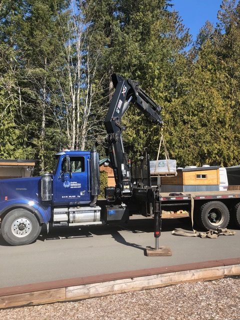 A blue truck with a crane attached to it