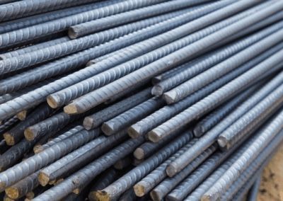 A pile of steel bars sitting on top of each other on the ground.