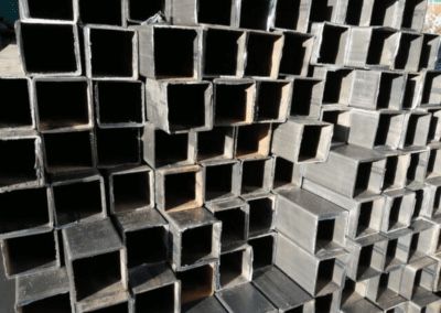 A pile of square metal pipes stacked on top of each other.