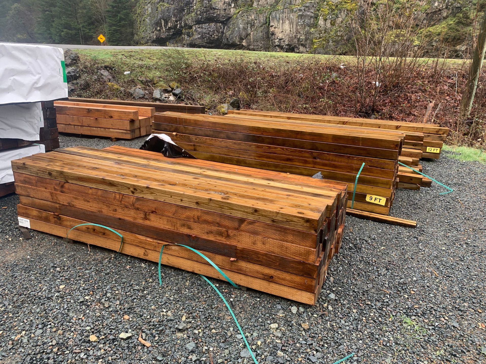 A pile of wood sitting on top of a gravel road.