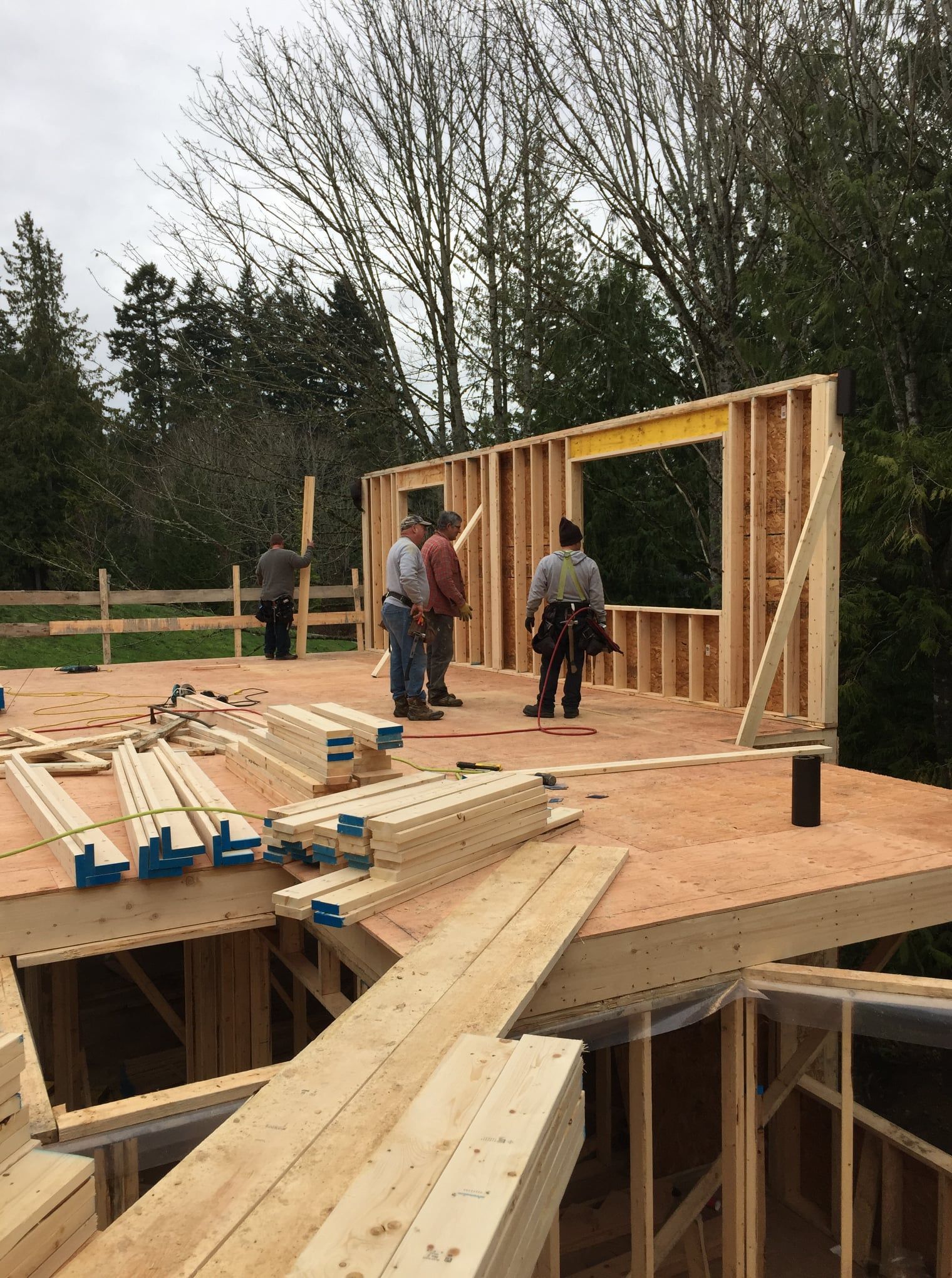 A group of men are standing on top of a wooden structure.