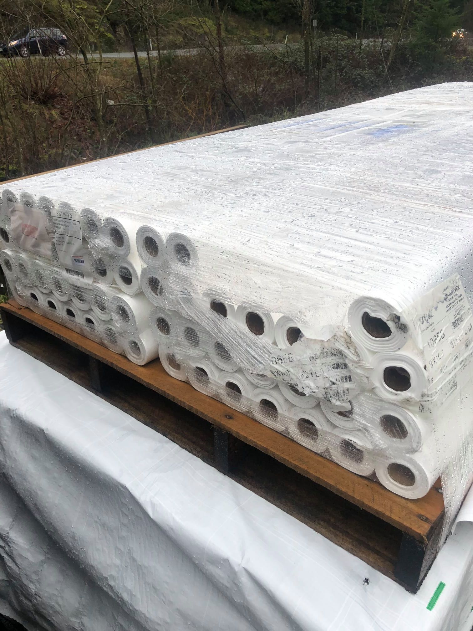 A wooden pallet filled with rolls of toilet paper.