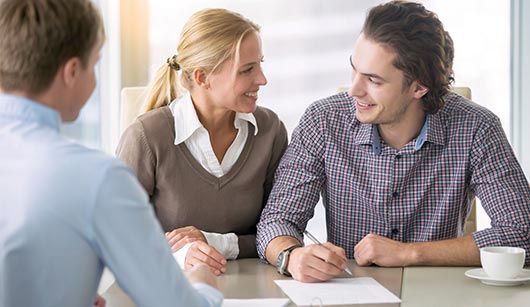 couple smiling on consultation — insurance agent in Sault Ste. Marie, MI