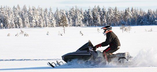 Man Driving a Snowmobile — Specialty Lines in Sault Ste. Marie, MI