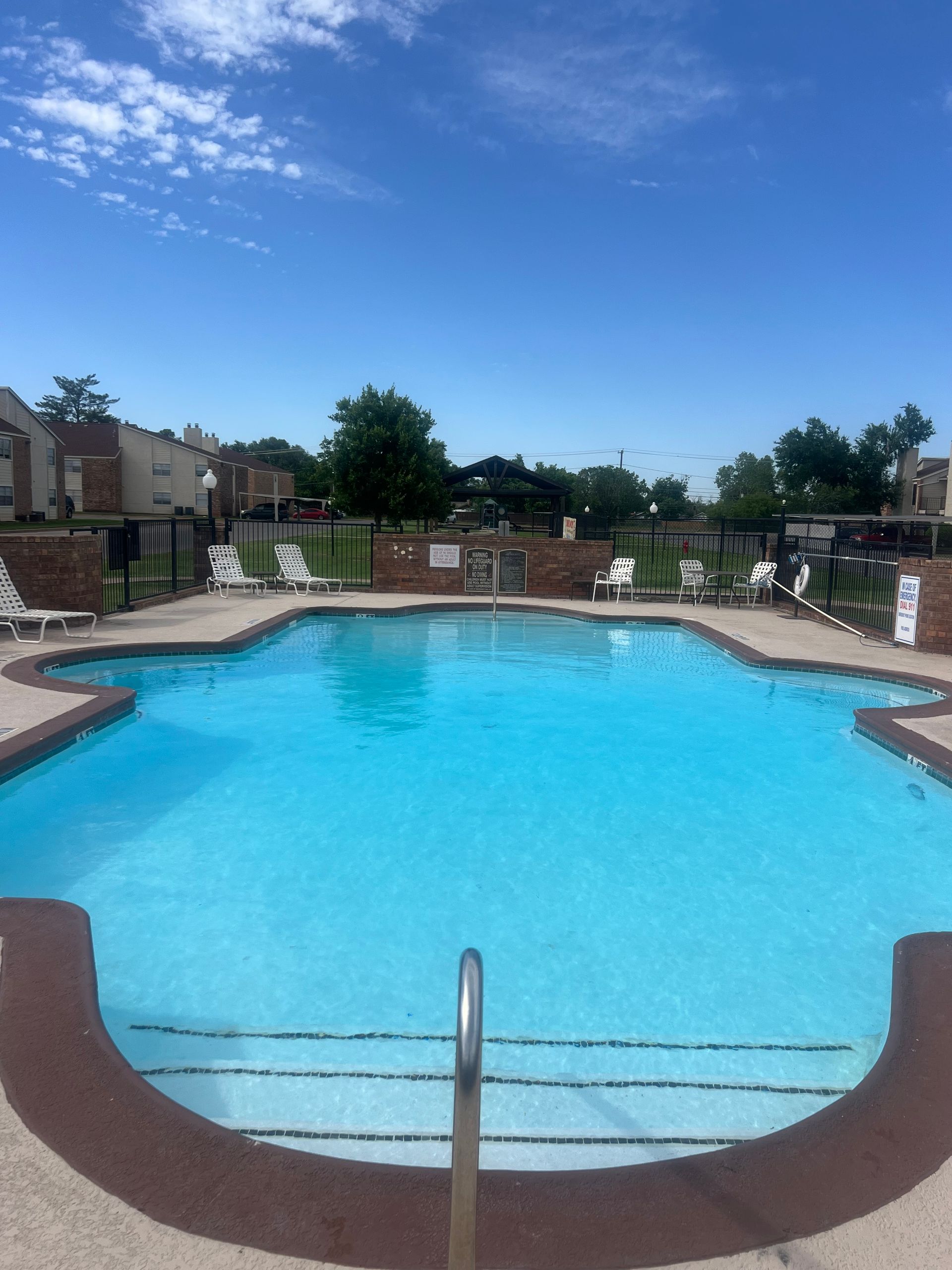 Swimming pool on a sunny day with a blue sky.
