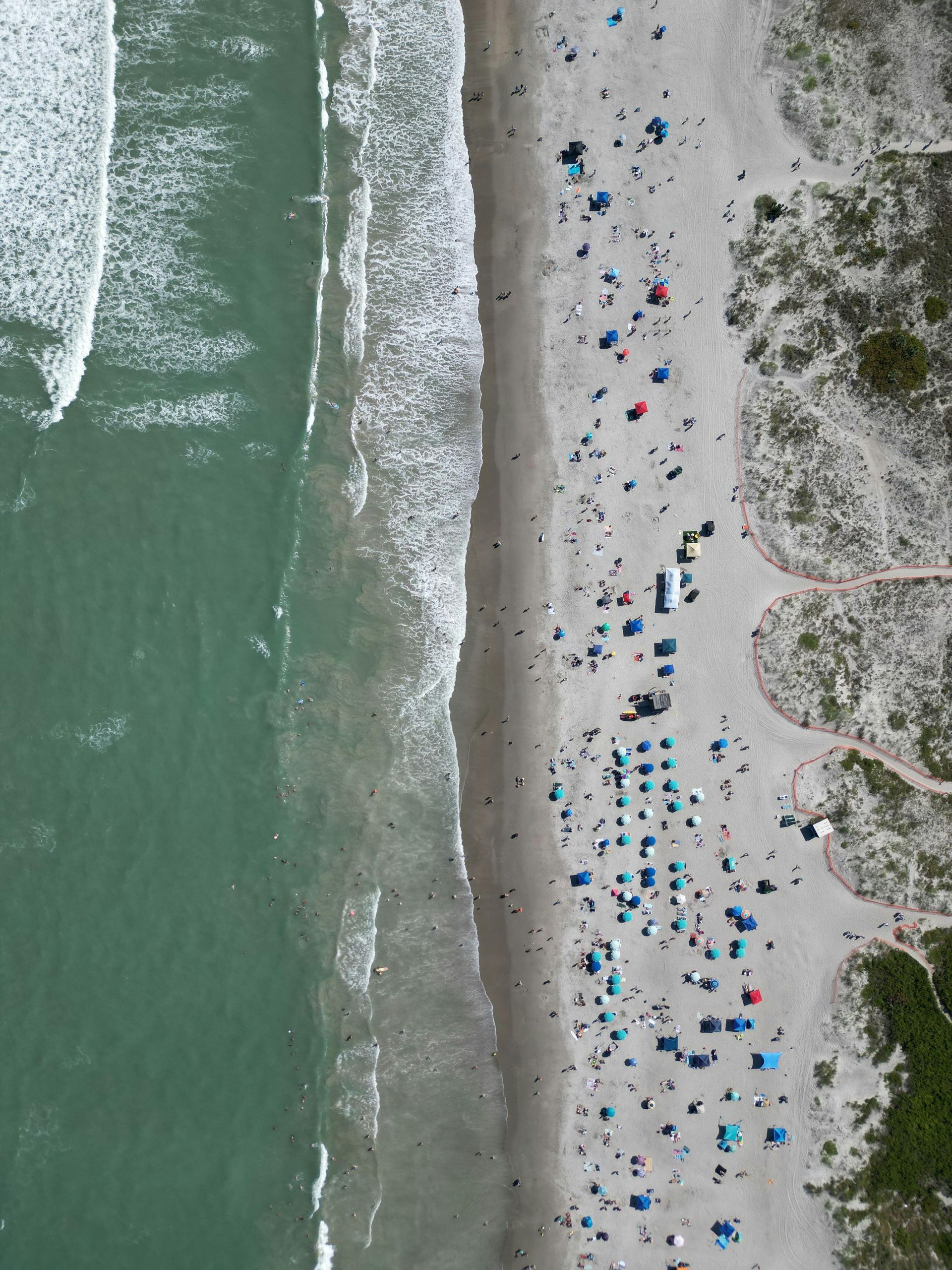 An aerial view of Santa Rosa beach with a city in the background.