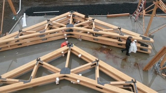 A group of people are working on a wooden structure