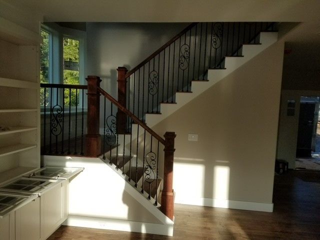 A staircase in a house with a wrought iron railing