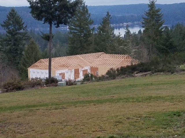 A house is being built in the middle of a grassy field