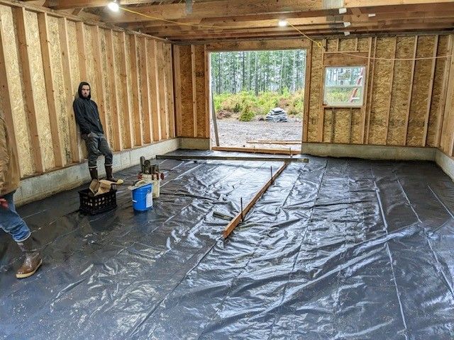 A man is standing in a room with a tarp on the floor.