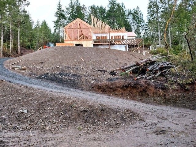 A house is being built on top of a dirt hill.