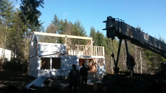 A house is being built with a crane in the foreground