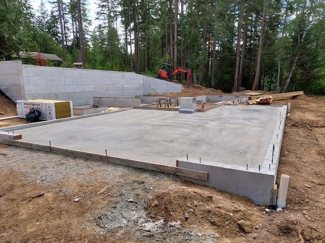 A large concrete slab is sitting in the middle of a dirt field.