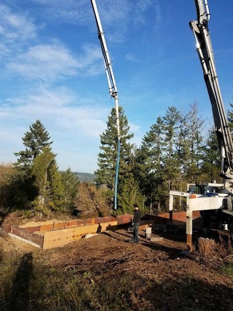 A concrete pump is being used to pour concrete into a foundation
