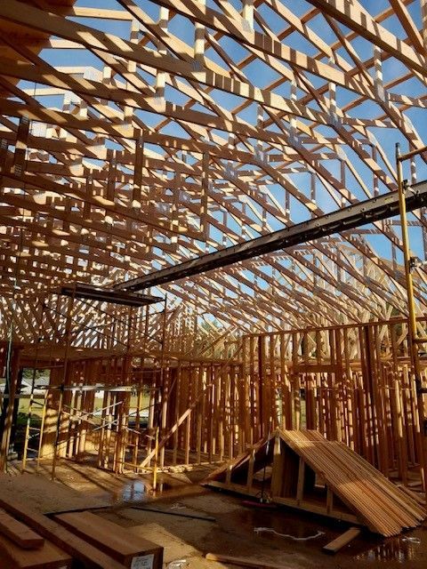 A large wooden structure is under construction with a blue sky in the background
