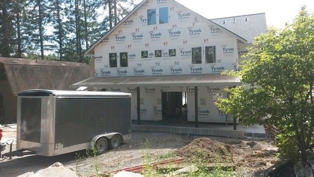 A trailer is parked in front of a house under construction
