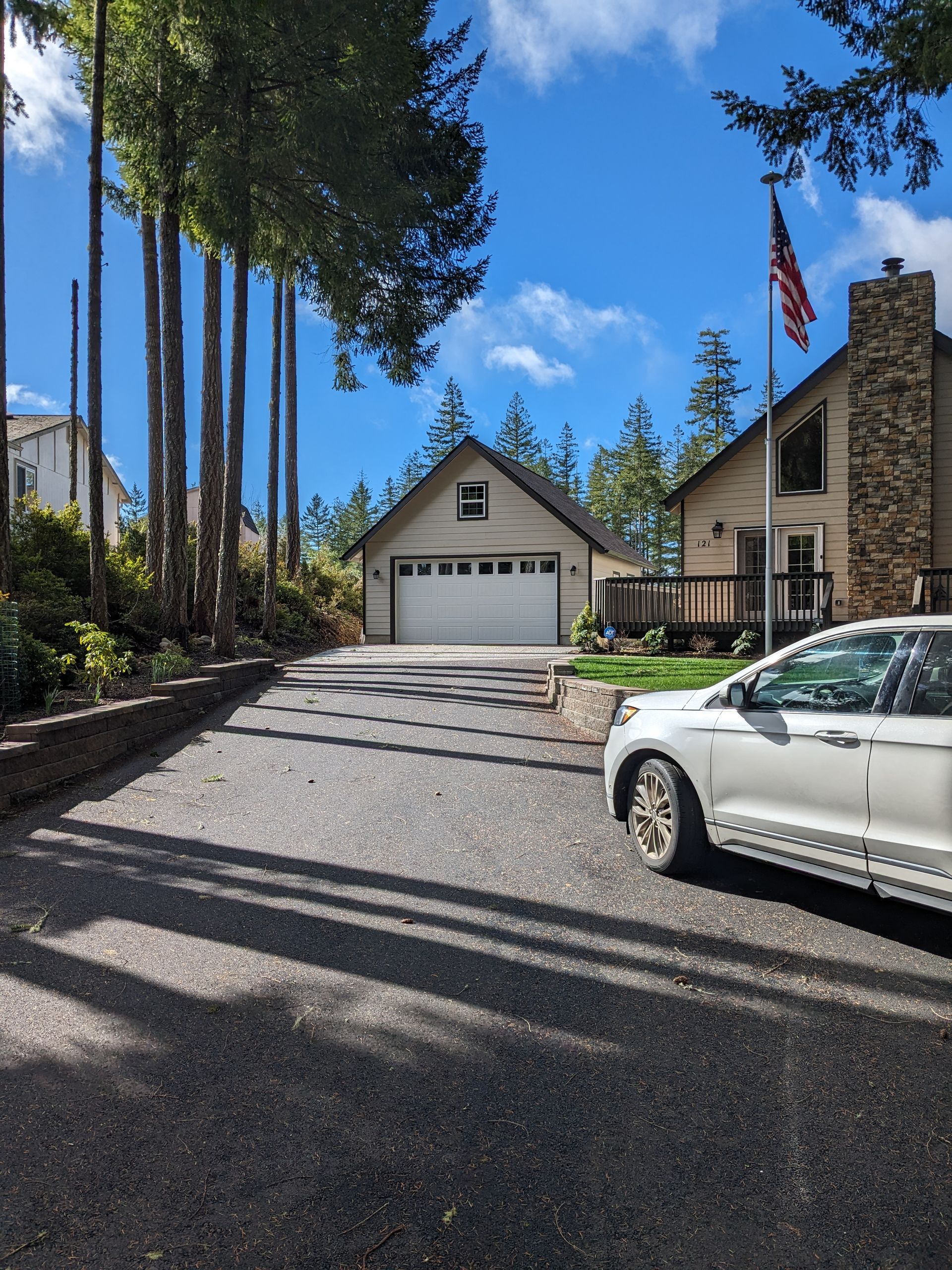 A white car is parked in front of a house