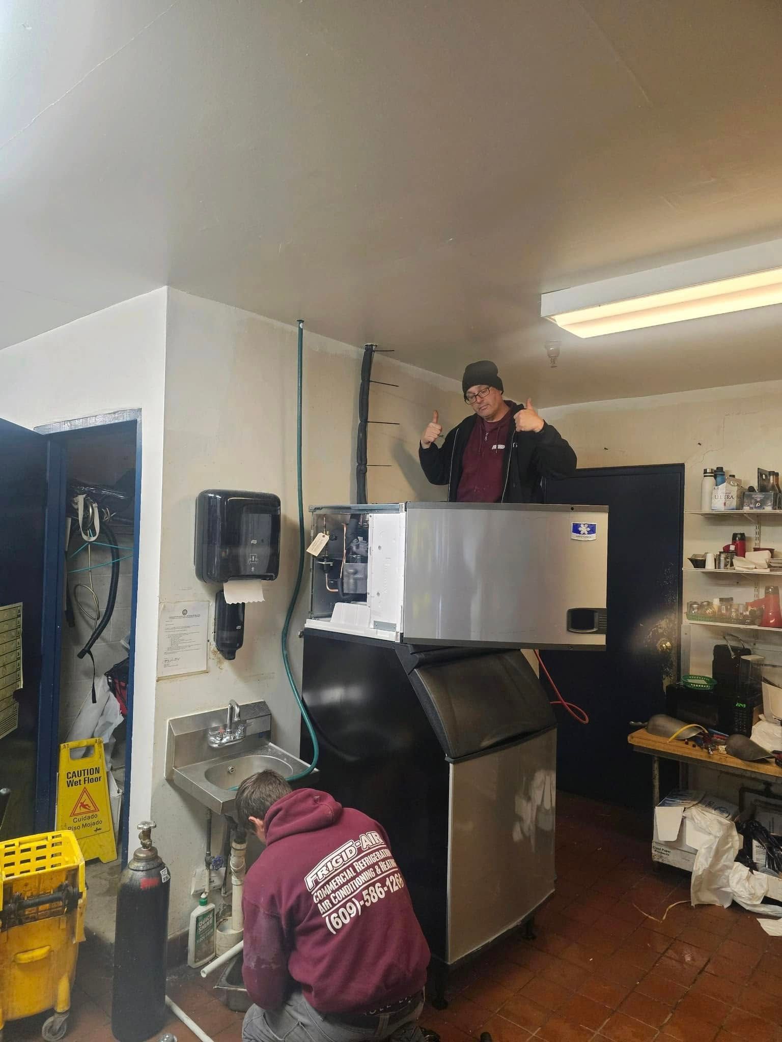 Woman and two toddlers on a couch looking at a tablet together, in a home setting.