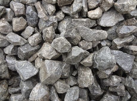 A close-up view of a pile of crushed grey angular rocks or gravel of varying sizes.