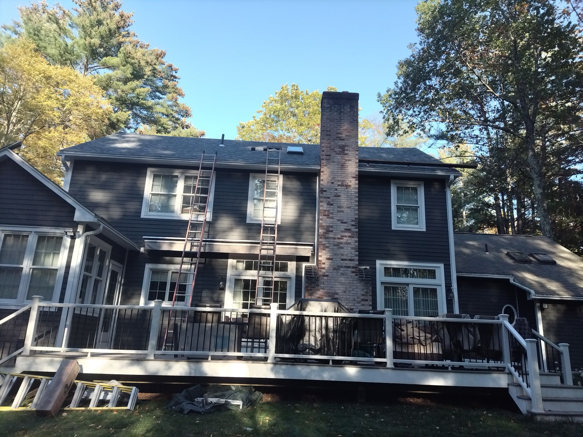 Blue house with stone accents, a brick pathway, and green lawn.