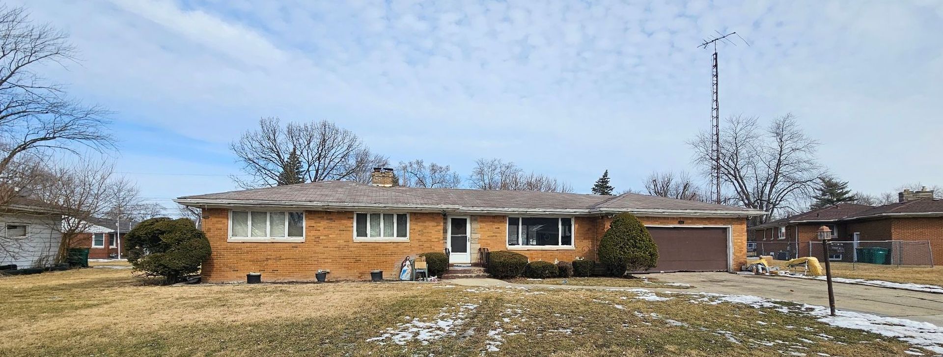 A large white house with a for sale sign in front of it.
