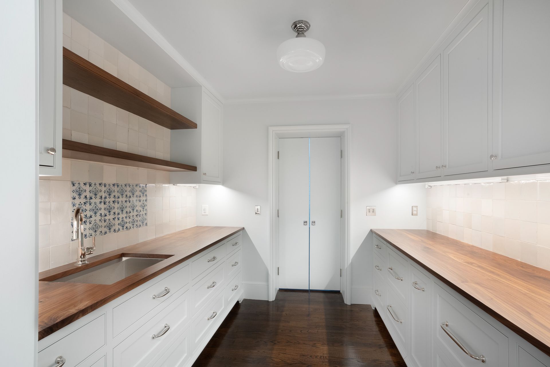A kitchen with white cabinets and wooden counter tops