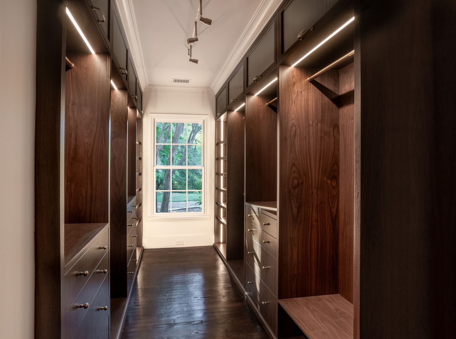 A walk in closet with lots of drawers and a window