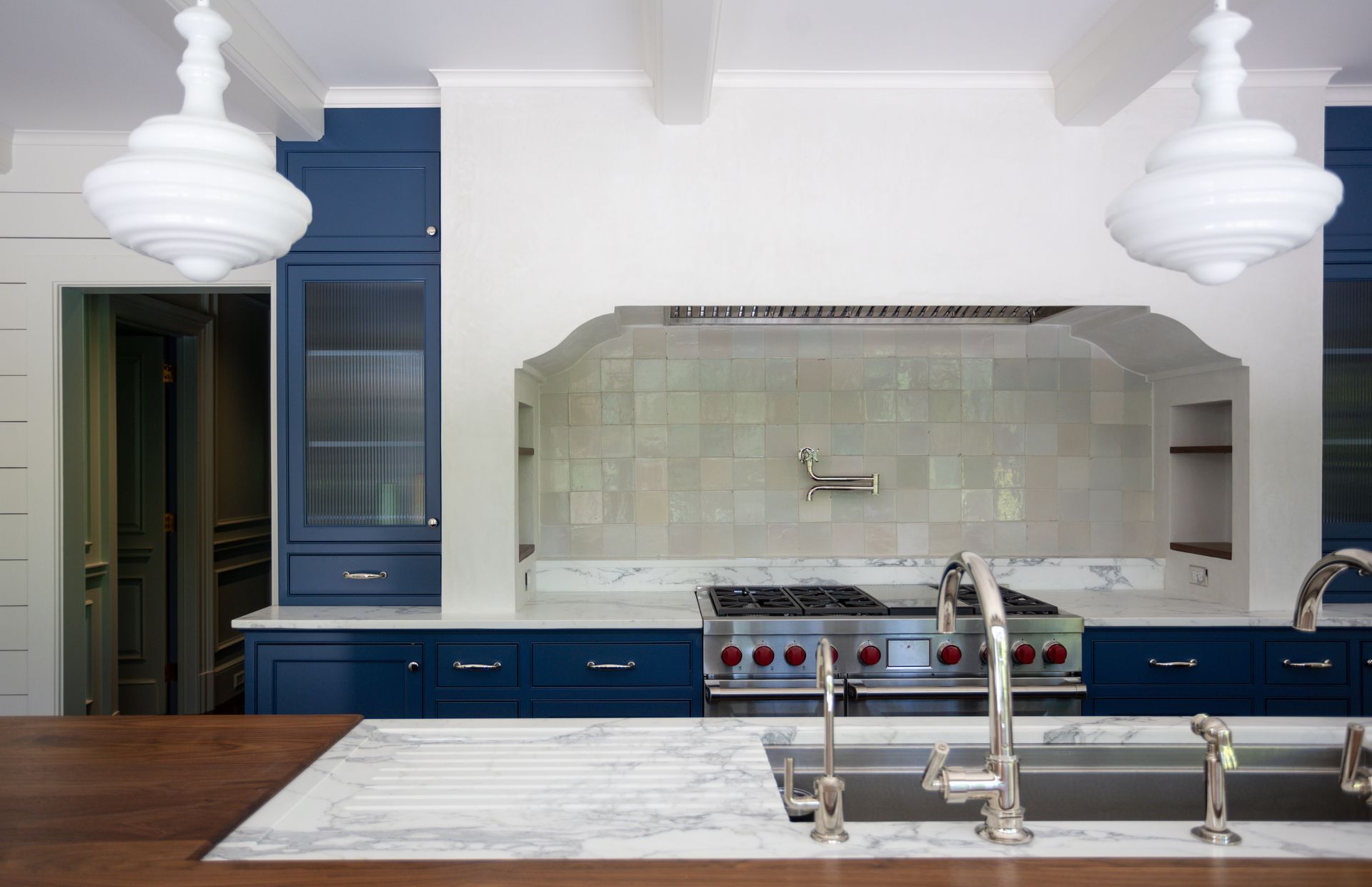 A kitchen with blue cabinets and white counter tops