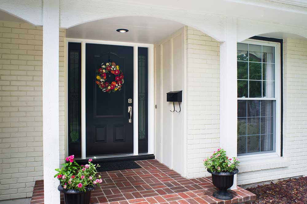 black entry door with decorative wreath