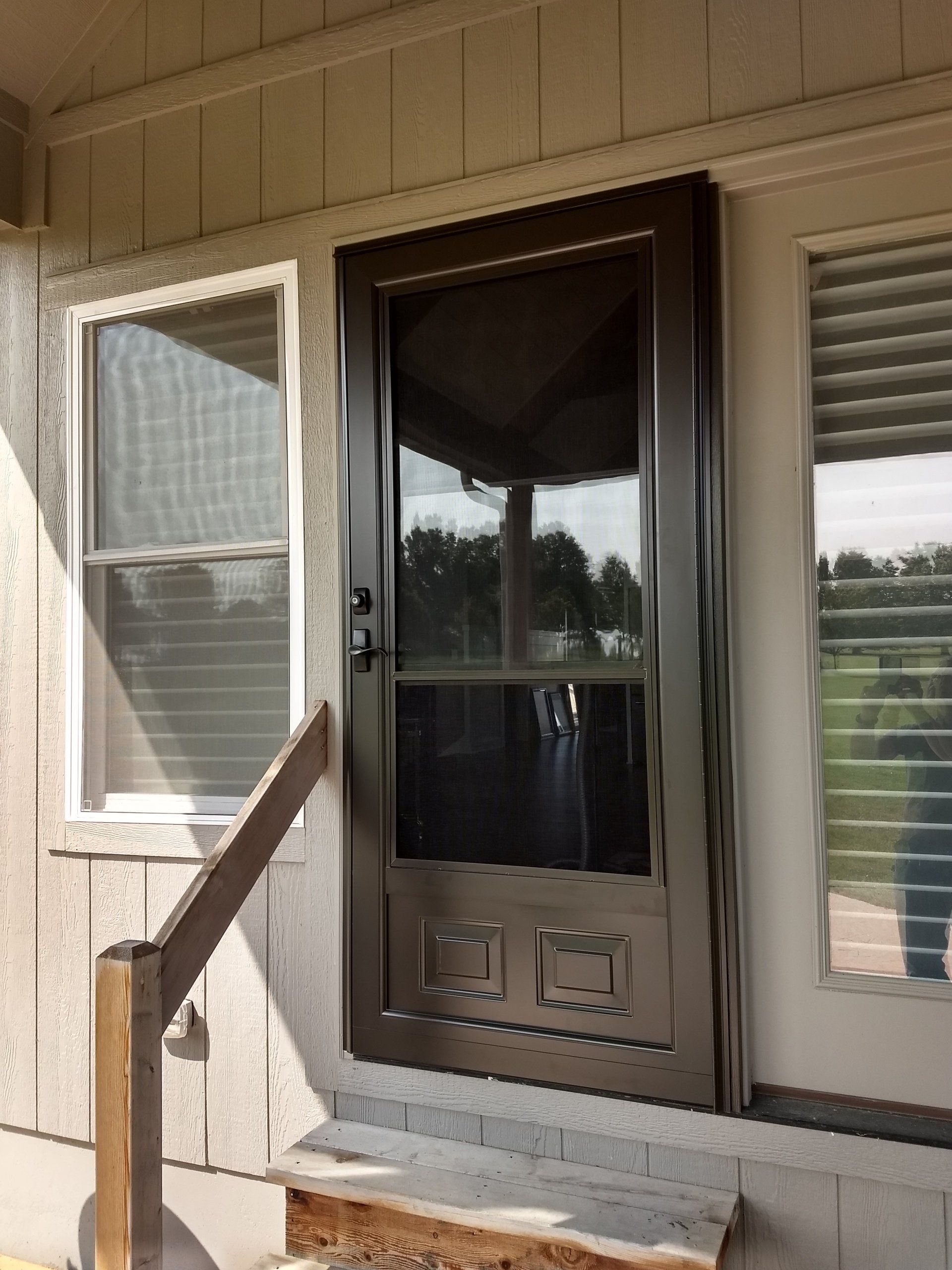 light brown storm door in front of home