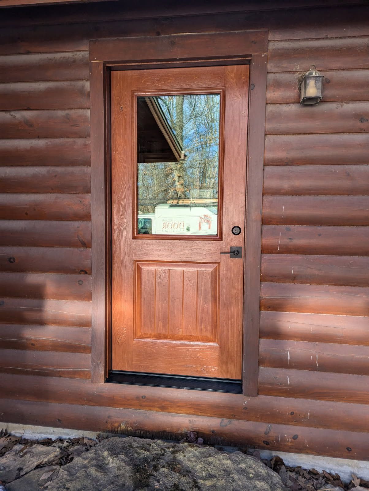 front entry door on brick home with black border and decorative glass