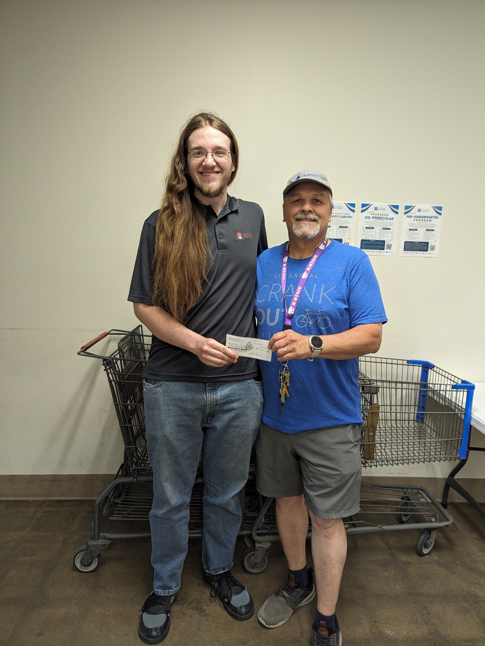 Avery Payne and a representative from Coldater are standing next to each other in front of shopping carts.