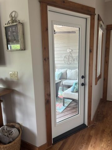 wooden entry door to brick home with decorative glass inlays