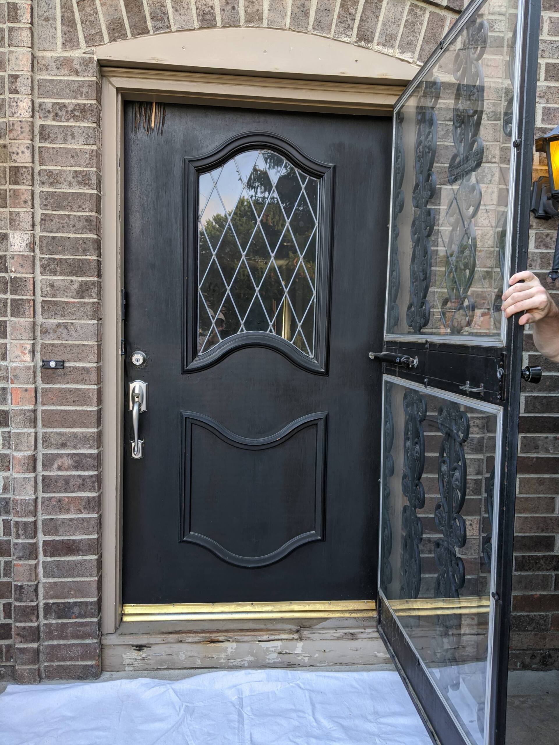 before picture of black recessed panel door with wear and tear