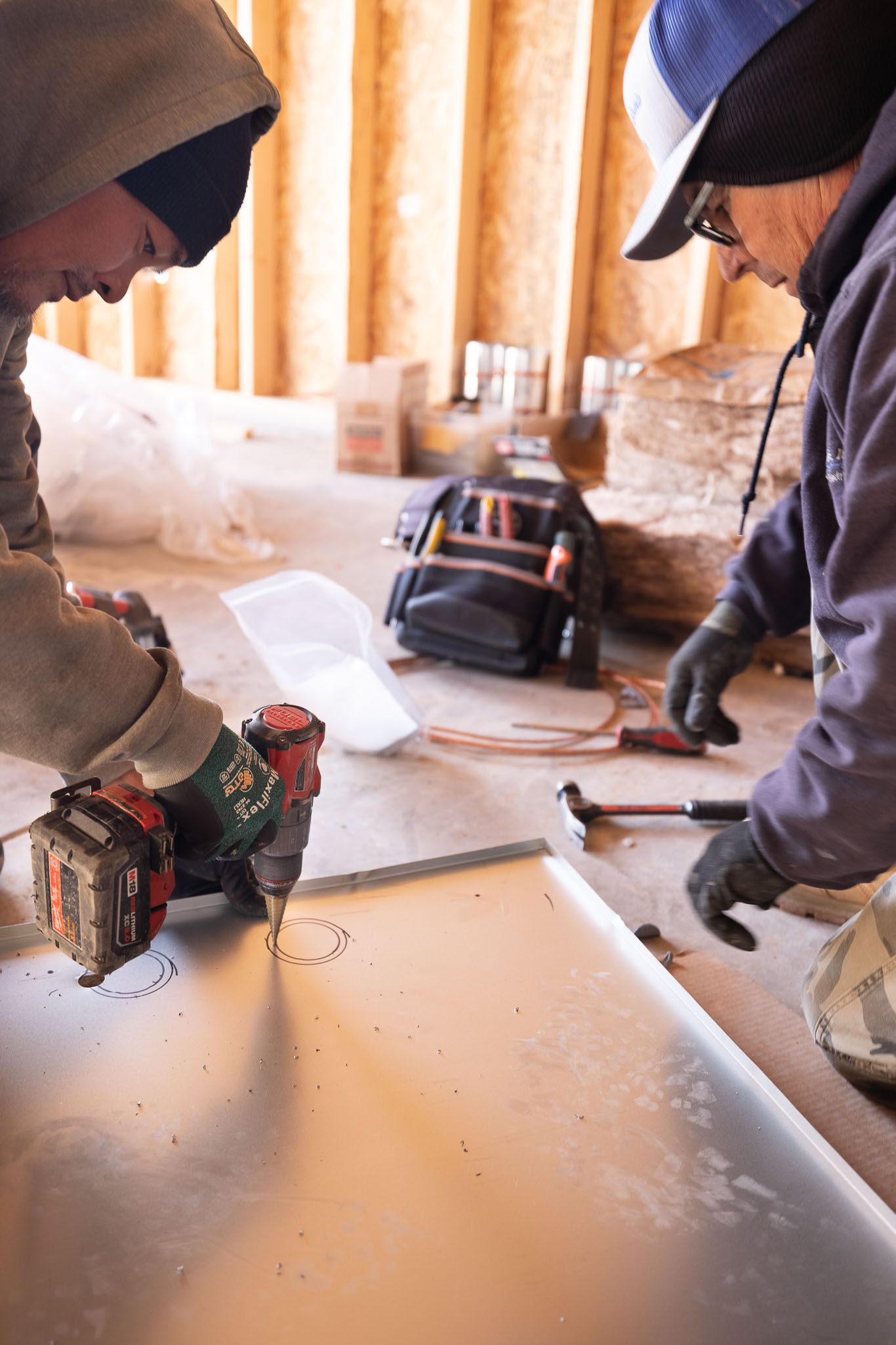 Nightlight Electric Employees cutting holes in electrical panels.