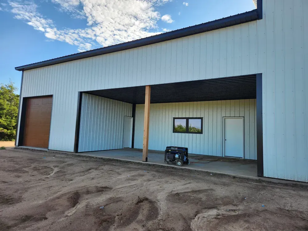 A large white building with a garage door and a generator in front of it.