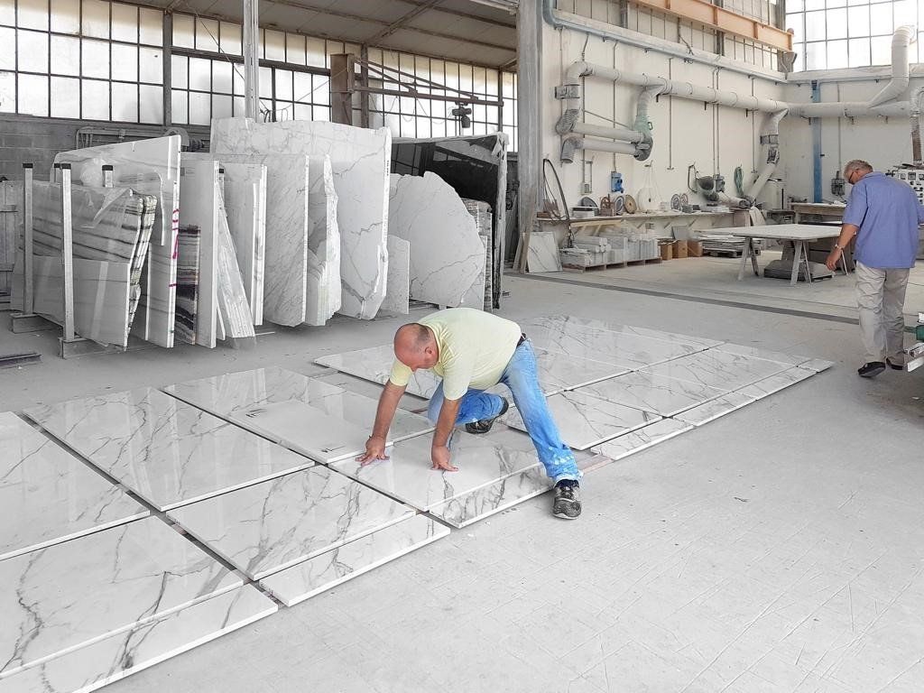 marmista che lavora con lastre di marmo bianco
