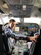 A man is sitting in the cockpit of an airplane.