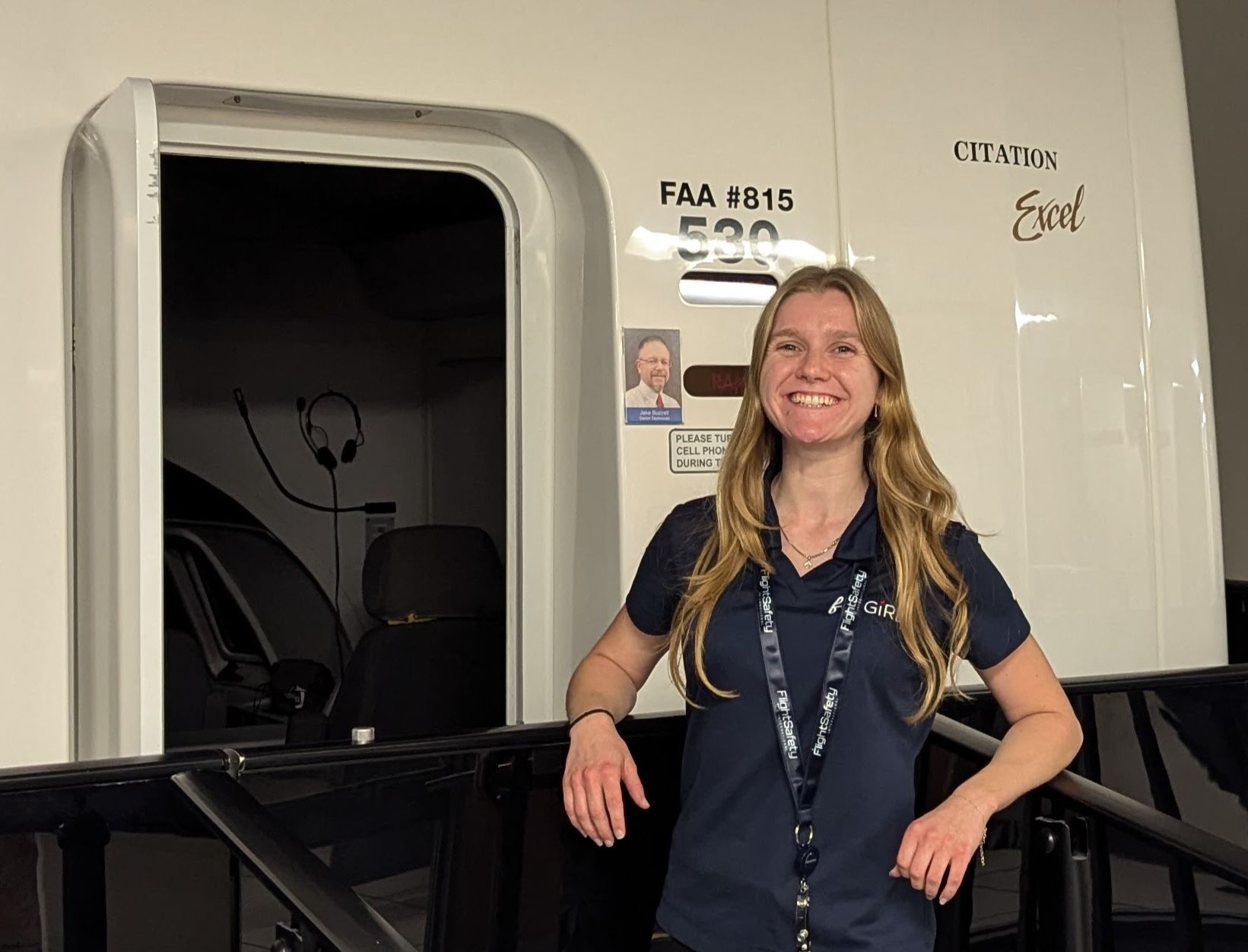 A woman in a blue shirt stands in front of a door that says fuel