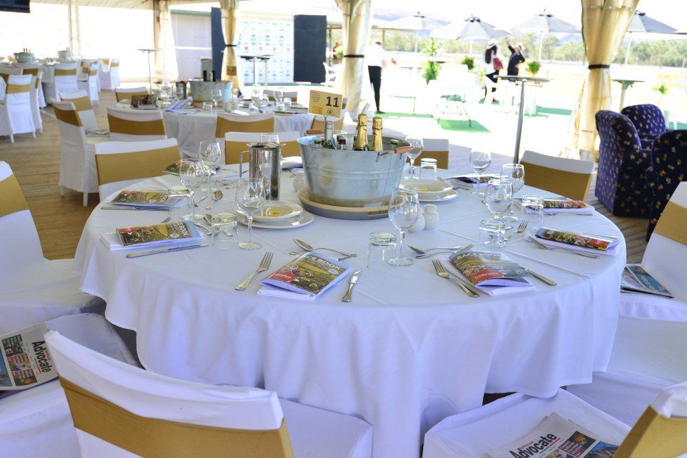 A round table with a white table cloth and gold chairs