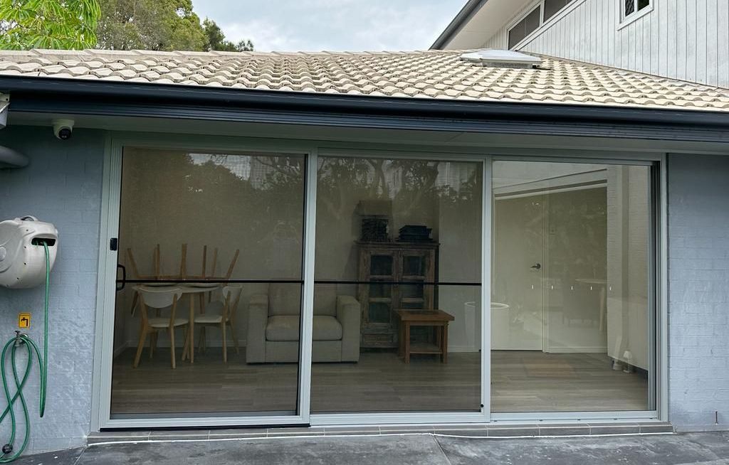 A house with a sliding glass door leading to a living room.