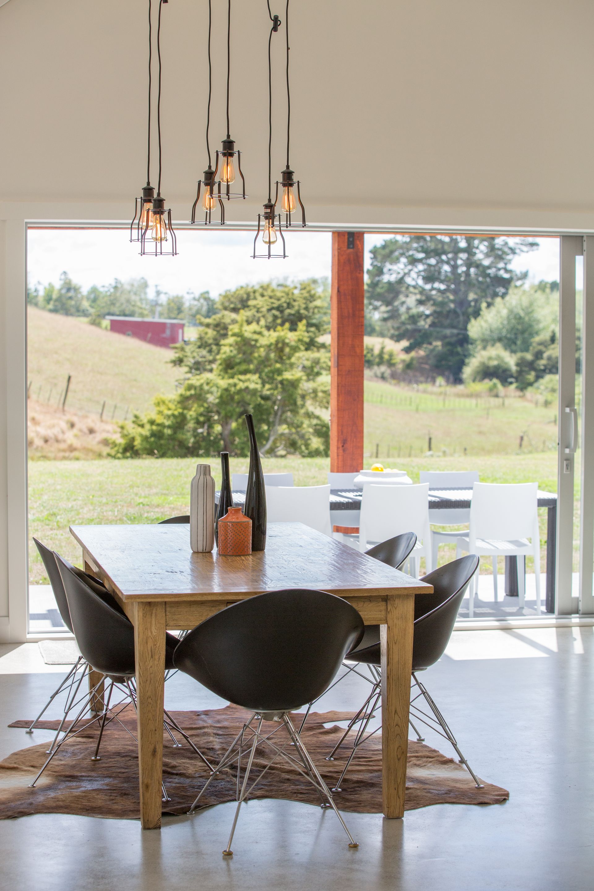Dining room with table, chairs, and outdoor view through sliding glass doors.