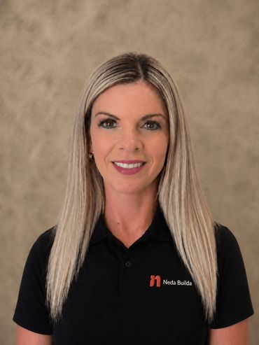 Portrait of a smiling woman in a black polo shirt against a neutral background. Karin, Operations Exec