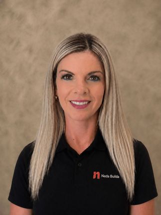 Portrait of a smiling woman in a black polo shirt against a neutral background. Karin, Operations Exec